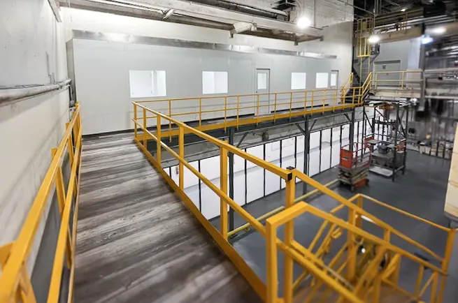 Modular office installed on mezzanine platform showing efficient use of vertical warehouse space