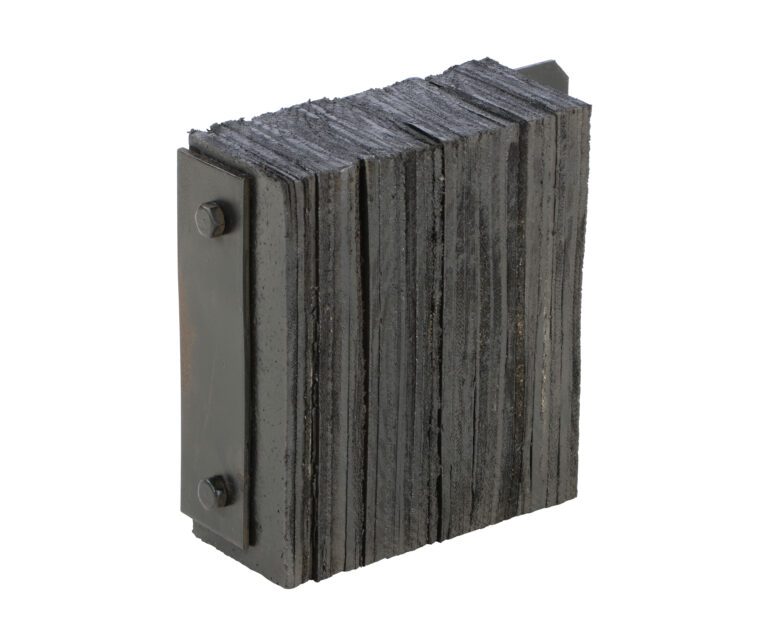 1214-4.5F_A.jpg Dark, rectangular plates, akin to the Vestil Laminated Dock Bumper 12 X 14 X 4.5In, are secured by two side bolts forming a block shape. The uneven edges create a rugged texture.