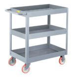 The gray utility cart, similar to the Little Giant 3-Inch Deep Shelf Truck, features a sturdy handle and red casters. Each of its three tiers has raised edges to keep items secure.