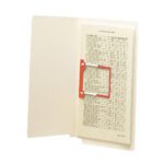 A beige folder showcases a single page held by a vivid red Smead U-Clip Bonded Fastener, 2 capacity. The list of names and numbers is neatly bound, with the folder placed upright against a white background.