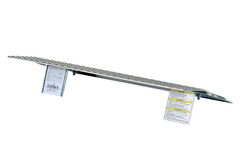 A metal attic ladder with an aluminum frame, similar to the Vestil Aluminum Hand Truck Dockplate 0.5K 36X24, is displayed folded horizontally. It features two white text labels and a grated slip-resistant surface for enhanced safety.