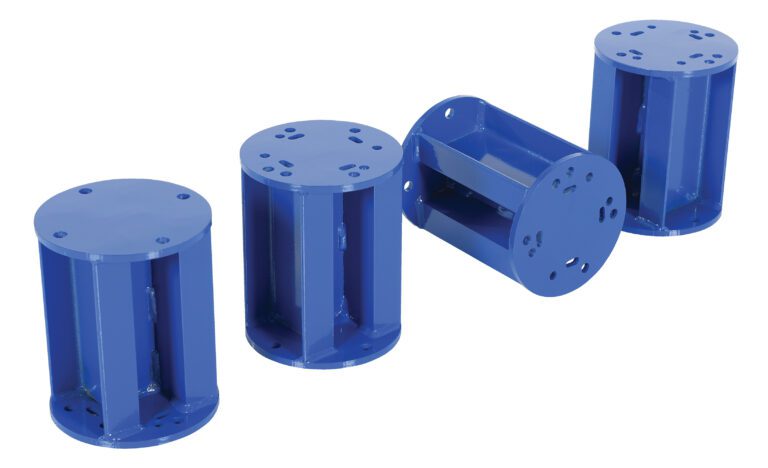 Four blue metallic cylinders with Vestil Stationary Leg Option (4) Field Install, each having six bolt holes on top, are displayed on a white background. One lies horizontally while the others stand upright, suggesting readiness for field installation.