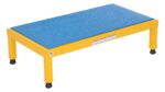 The Vestil Adj Steel Stand 10.5-16.5 H 19 X 36 has a small rectangular platform with a yellow frame and textured blue surface. It features four sturdy legs with adjustable black non-slip rubber feet ranging from 10.5 to 16.5 inches in height, plus a visible label on the side.