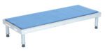 A rectangular metallic grooming table with a blue padded top, four adjustable legs like the Vestil Adj Alum Stand 9.5-15.5 H 19 X 48, each equipped with non-slip rubber feet for stability.