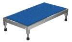 The Vestil Adjust Ss Stand 6.75-8.75 H 19 X 36 features a blue textured surface on its rectangular metal platform with four adjustable legs and black rubber feet for stability, making it sturdy and functional for industrial or workshop use.