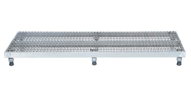 A metal grate platform similar to the Vestil Adj Ss Work Stand 6.75-8.75 H 23.5 X 96, featuring a textured open mesh surface and supported by four short legs, with three legs having black caster wheels for easy mobility.