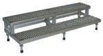 The Vestil Adj Ss Step Mate Stand 2 Step is a sleek silver metal platform with perforated steps for industrial use. It measures 59.75 x 22.75 inches and includes adjustable legs and black rubber feet to ensure stability on various surfaces.