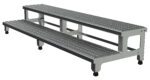 The Vestil Adj Alum Step Mate Stand 2 Step 72.06 X 22.75 features a metal two-step portable platform with a textured surface for grip, sturdy frame, and wheels for easy mobility, perfect for industrial or commercial use.