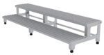 The Vestil Adj Ss Step Mate Stand 2 Step, measuring 71.75 x 22.75 inches, features a gray two-tier aluminum bleacher with non-slip surfaces and black-capped feet, ideal for both indoor and outdoor use.