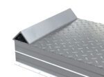 Close-up of a Vestil Alum Tread Whl Riser W/ Roll Of Guard 60X18X8, featuring its diamond plate texture with raised patterns for grip. The sharp, angular design and reflective surfaces make it perfect for industrial flooring and heavy-duty applications.