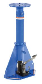 A tall, blue device with a round top platform and a base lever-spring mechanism resembling the Vestil Adjustable Height Work Stand, it efficiently elevates heavy objects like a hydraulic lift or jack stand.