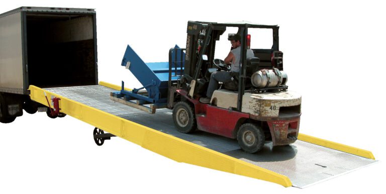 A forklift operator skillfully ascends a Vestil Yard Ramp with Option-Yellow Curb Paint, guiding it into a truck trailer. The forklift, carrying a large blue object, moves seamlessly amidst the lively industrial loading dock.