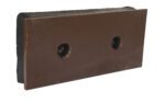 This brown, rectangular metal plate resembles the durable design of a Vestil Steel Face Molded Rubber Bumper 18X8X2-1/2 Blk. It features beveled edges, two central circular holes, and a matte finish with subtle wear marks against a white background.