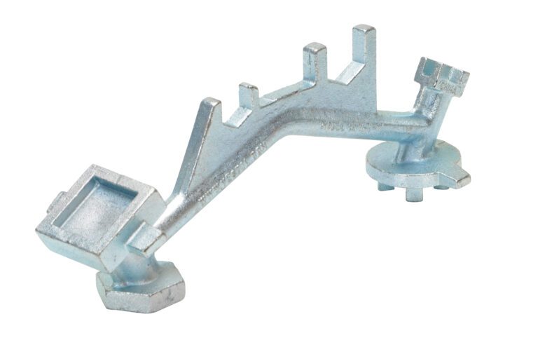 BNW-I-W_A.jpg The Vestil Zinc Angled Hand Drum Bung Nut Wrench has a metal key with various notches and unique geometric shapes, ideal for specialized locks or machinery, shown isolated on a white background.