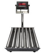 The Vestil Bench Scale SS Tray Roll Top 24x24 1000 includes a digital display with red numbers and multiple control buttons. It has a platform of parallel metal rollers for weighing large objects, with the display mounted on a vertical stand attached to the base.