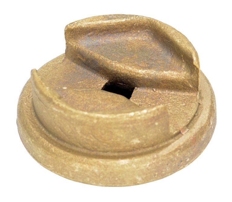 The Vestil Bronze Drum Bung Socket 1/2 In Drive is a round, bronze-colored metal object with a central square hole and two perpendicular raised edges, featuring an industrial design with its textured, slightly worn surface that enhances its rugged appearance.