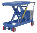 The Vestil Trac Drive Hyd Elev Cart 20X40 2000 24Dc features a blue scissor lift table with red wheels and gray handles, equipped with a robust hydraulic mechanism and a flat rectangular platform for dynamic lifting needs.