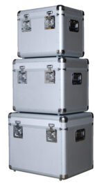 Three Vestil Aluminum Cases, varying in size with the largest at the bottom, are stacked. Each silver metal case features reinforced corners and side metal handles.