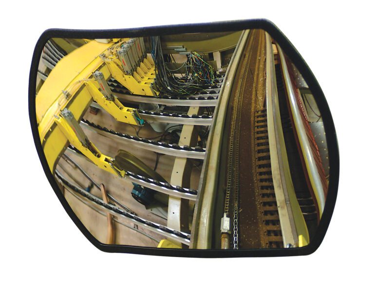 The Vestil Convex Mirror Rectangular 26 Ft Distance captures an industrial setting featuring machinery with yellow components, wires, and metal tracks, reflecting the manufacturing environments mechanical focus.