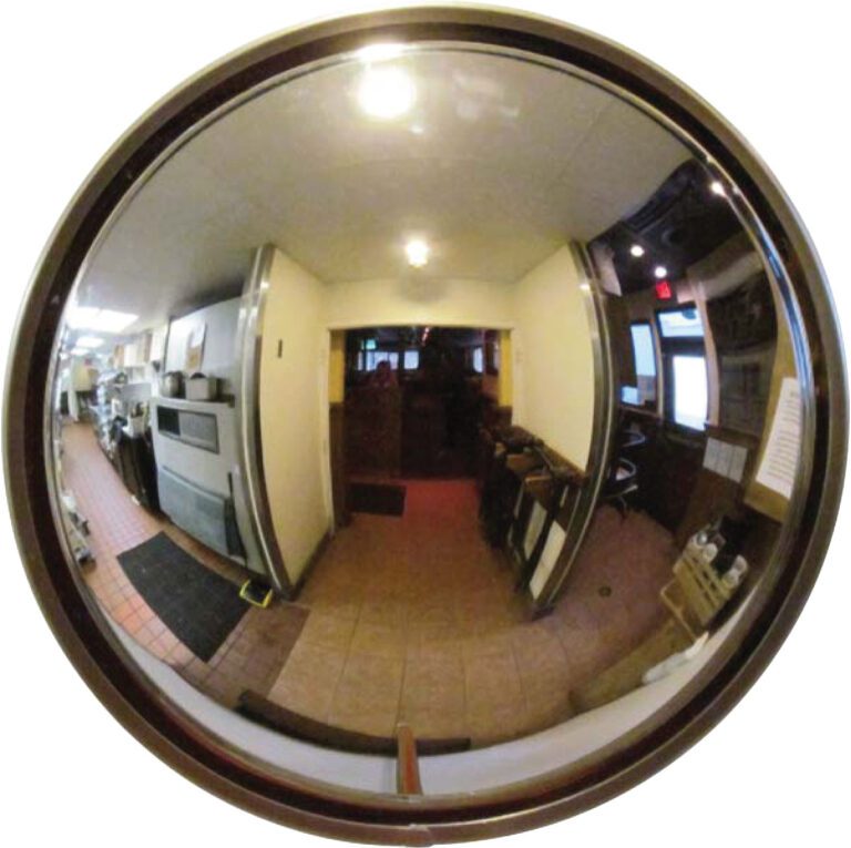A fisheye view of a narrow, dimly lit corridor shows a Vestil Convex Mirror Outdoor 16-20 Ft 4 In Deep. It reflects the kitchen on the left and the seating area on the right, distorting kitchen equipment and chairs along this elongated passage.