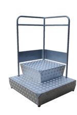 The Vestil Container Step Platform, 31 x 31 inches, supports up to 485 lbs and features a checkered metal podium step with two levels. Surrounded by minimalist railing, it boasts a simple industrial design in a sleek silver finish.
