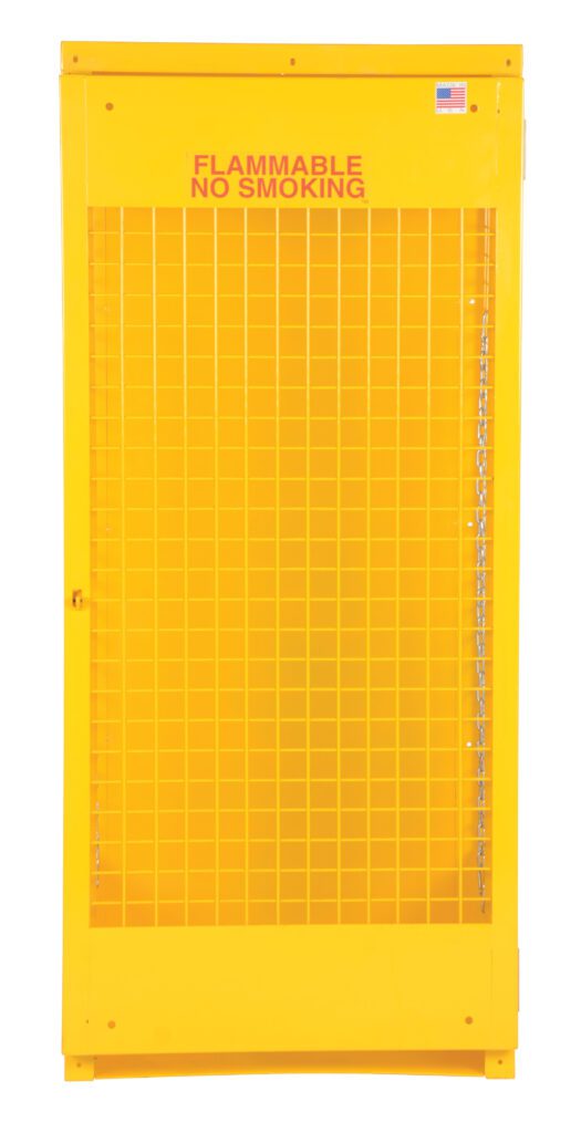 The Vestil Vertical Cylinder Cabinet-5-10 is a tall, bright yellow unit with a mesh front and FLAMMABLE NO SMOKING in red at the top. An American flag sticker in the upper right corner enhances its appearance, making it perfect for storing flammable materials securely.