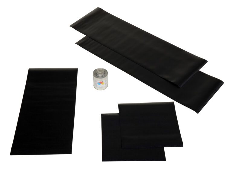 Five black rubber patches of different sizes, included in the Vestil Dock Seal Option Repair Kit, are arranged alongside a small spray can for repairs. The black items stand out against the white background.