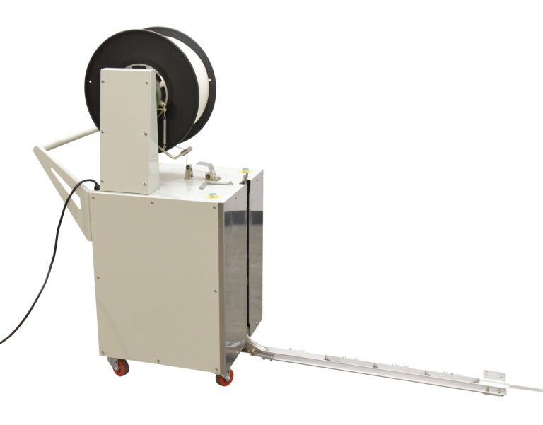 DBA-130_A.jpg The Vestil Semi-Automatic Probe Strapping Machine is a portable white unit with wheels, featuring black strapping material on top. It includes a measuring-marked metal extension arm and an attached power cord for effective use.