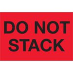 A vibrant red sign with bold black letters reads DO NOT STACK, similar to MH-USA 2 x 3 fluorescent red labels (500/roll).