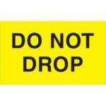 A yellow sign with bold black text reading DO NOT DROP resembles the MH-USA 3 x 5 - Do Not Drop fluorescent yellow labels (500/roll), ensuring high visibility and serving as a critical reminder.
