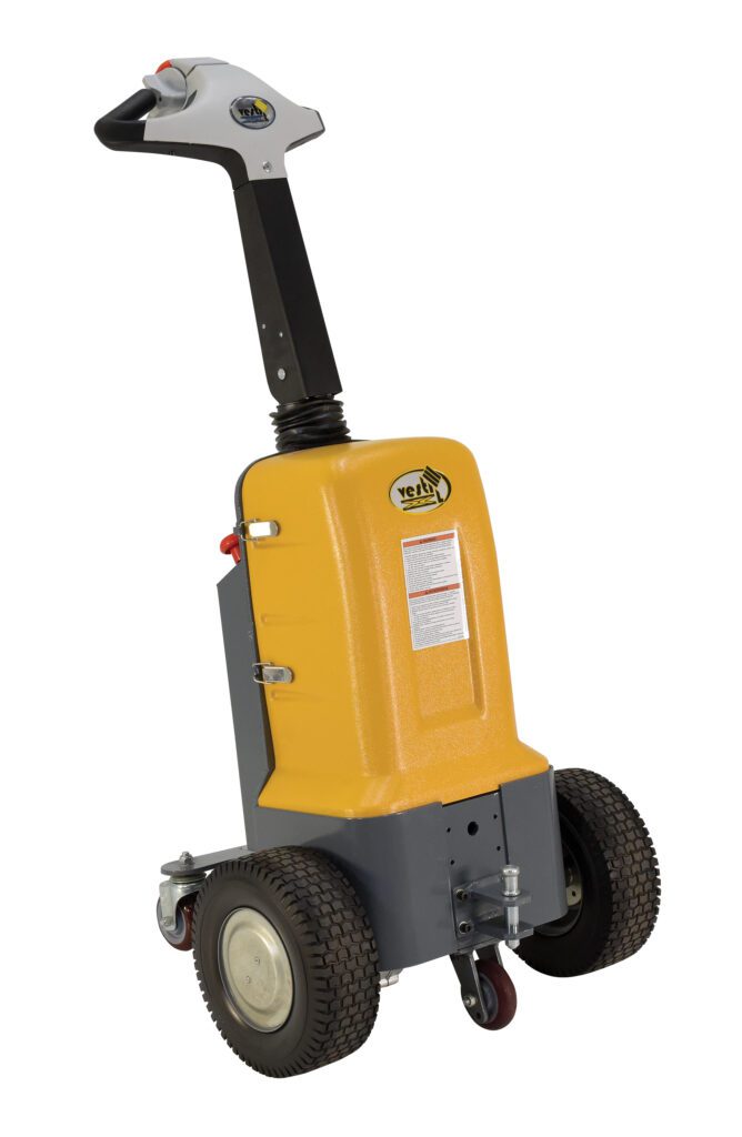 The Vestil Electric Powered Tugger, in yellow and gray, features a control panel on its handle, two large rear wheels, a smaller front wheel, and visible side labeling. It offers an impressive 2K pull capacity.