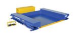 The Vestil Ground Lift Scissor Table 2K 44 X 51.5 showcases a blue and yellow design, including a yellow foot pedal control. Its flat base with raised sides uses a hydraulic mechanism, and vestil.com appears on the yellow panel.