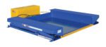 A blue and yellow hydraulic dock leveler from vestif.com, featuring adjustable height, a platform surface, and safety labels, perfectly complements the Vestil Ground Lift Scissor Table 4K 44 X 51.5 for seamless operations.