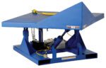 The Vestil Elect/Hydraulic Corner Tilter 4K 48 X 48 includes a blue industrial lift table with a slanted platform, exposed hydraulics, safety labels, yellow coiled wire, and two bottom slots for easy maneuvering.