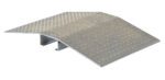 The Vestil Fab Alum Hose & Cable Crossover 24X44X4 is a sturdy metal ramp with a diamond plate surface, perfect for loading docks. Its slightly raised center enhances its ability to efficiently support heavy loads.