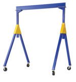 The Vestil Fixed Height Steel Gantry Crane 4K 10 Ft features a blue frame with yellow braces, a rectangular top beam supported by two angled legs, and wheels for mobility, offering a minimalist design centered on functionality.