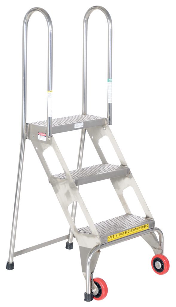 FLAD-3-SS_A.jpg The Vestil Folding 3 Step Ladder W/Wheels Ss is a metal safety ladder with three wide steps and handrails marked Safety First in English and Spanish. It features two red front wheels for mobility and two rear supports for stability.