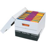 A white Bankers Box labeled R-Kive 724, measuring 15 x 12 x 10, is open, revealing colorful file folders in blue, orange, yellow, and red. Its partially lifted lid contrasts sharply against a plain background, much like the black R-Kive® File Storage Boxes (12/Case).