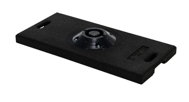 The Vestil Recycled Rubber Large Base W/Handle is a black, rectangular rubber base with rounded corners and a circular central component. It has handles on two sides and a textured surface, ideal for mounting or stability purposes.