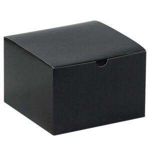 A rectangular black cardboard box with a closed lid has a small semicircular cutout on the front edge for easy opening. It features a smooth matte surface, resembling the sleek design of the MH-USA 6 x 6 x 4 Black Gloss Gift Boxes (100/Case).
