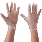 Two hands in MH-USA Vinyl Gloves Clear - 5 Mil - Powder Free - Medium (100/Case) are raised on a white background, showing slightly translucent gloves with palms forward, offering practicality and clarity.
