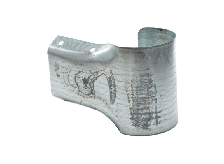 The Vestil Guard Rail System Buffer End Guard is a metallic, U-shaped bracket with two mounting holes on its textured top left surface. Its visible scratches and marks add to its rugged, worn appearance.