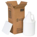 An open MH-USA 6 x 6 x 12 3/4 Shipper Kit reveals a white plastic jug. A piece of white foam leans against the box, which displays shipping symbols and text for the one-gallon jug inside.