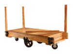 The Vestil Wood Platform Tilting Truck 48 x 24 has a sturdy wooden platform, four metal wheels, and detachable vertical posts at each corner, perfect for efficiently transporting heavy items.