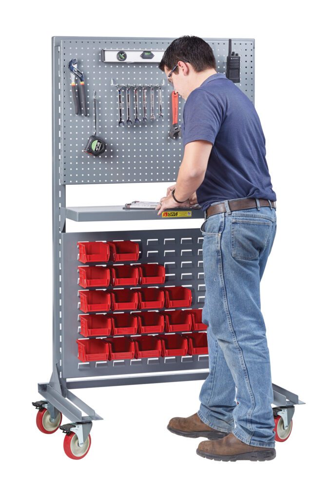 Dressed in a blue shirt and jeans, a person stands at the Little Giant Heavy-Duty Mobile Work Center - Single Sided (Frame Only), utilizing its red storage bins and pegboard full of tools to skillfully work on the surface.