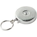 A silver tape measure features a textured metal casing and keyring attachment reminiscent of the Original KeyBak® Retractable Key Holder, with an elegantly designed circular casing seamlessly connected by a small chain link.