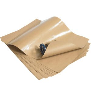 A partially curled top sheet from the 18 x 24 - 50 lb. Poly Coated Kraft Paper bundle reveals a coiled blue rope underneath, with the glossy finish reflecting light to enhance its allure.