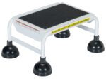 A white elevated platform like the Vestil Spring Loaded Roll Ladder 1 Step White, with a black non-slip top and four wide rubber-capped legs. It has a yellow SAFETY FIRST SEGURIDAD PRIMERO warning on the side.