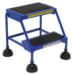 A blue two-step safety stool features black rubber grips, suction cup feet, and a SAFETY FIRST SEGURIDAD PRIMERO label on the top step. It emulates the sturdy design of a Vestil Spring Loaded Roll Ladder 2 Step Blue, prioritizing safety and stability.