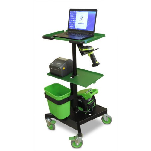 A wheeled workstation cart with three shelves. The top shelf holds a laptop; the middle shelf has a printer and a scanner. The bottom shelf contains a green bin and a power drill. The cart has green and black coloring and gray wheels.